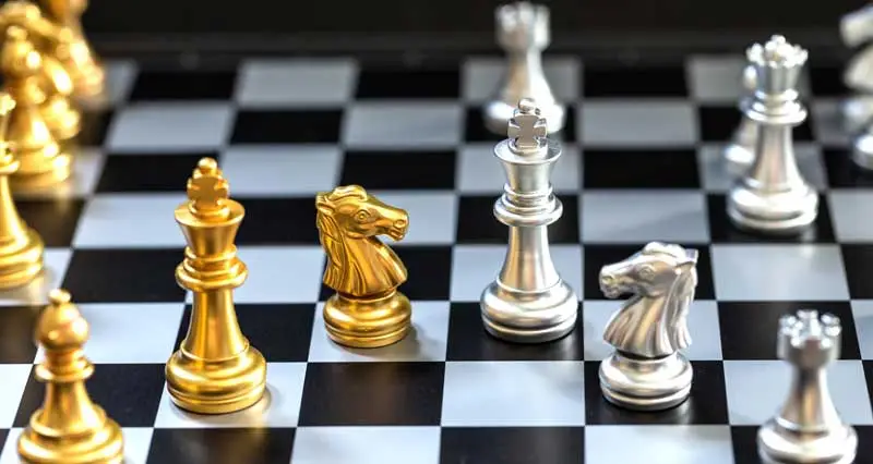 Schachbrett mit goldenen und silbernen Schachfiguren